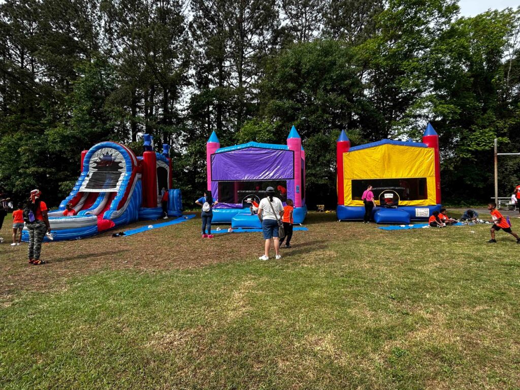 Families enjoying bounce house attractions at an outdoor event in Atlanta